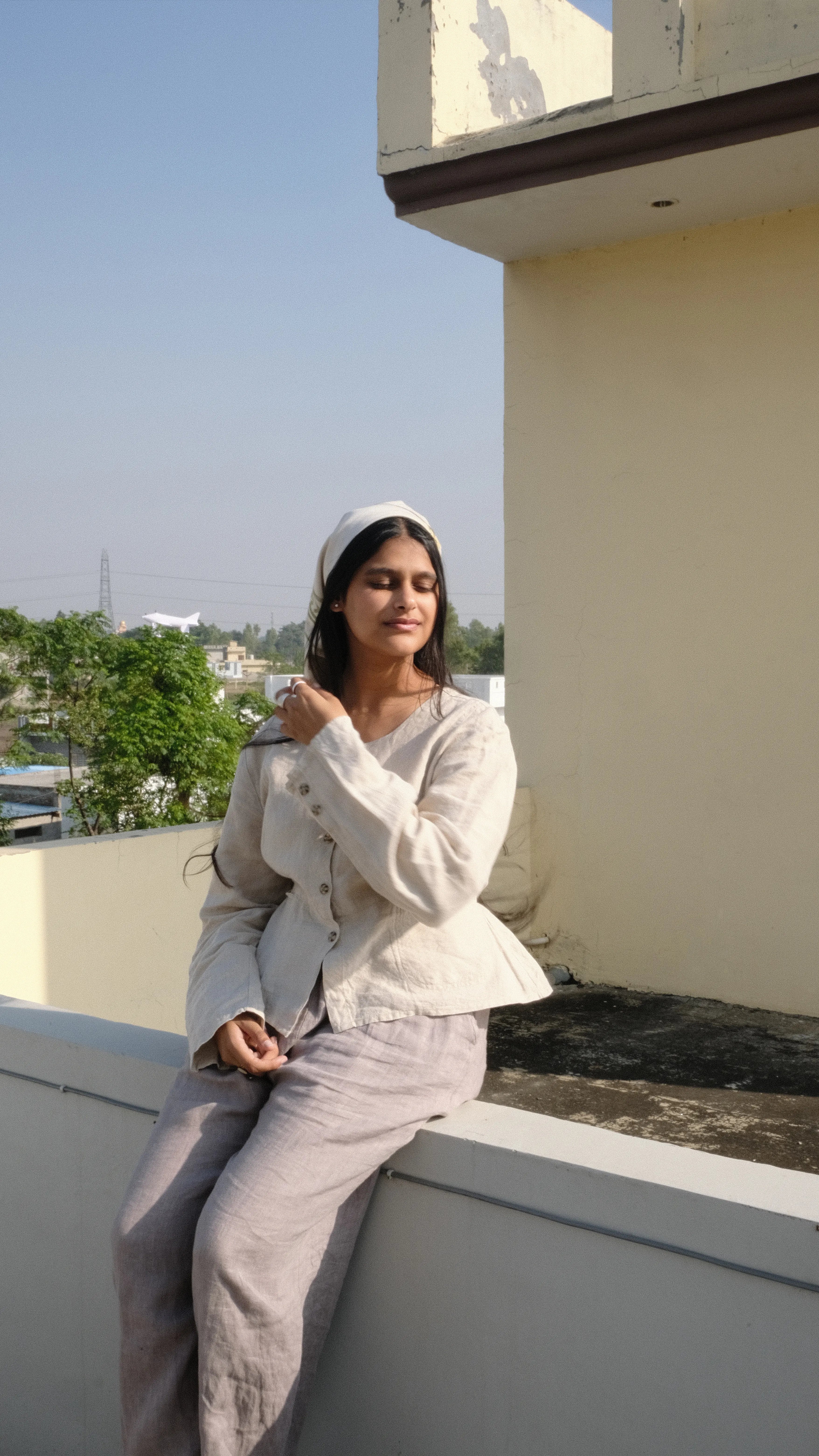 Girl sitting on rooftop on panjab styled with a  scarf 