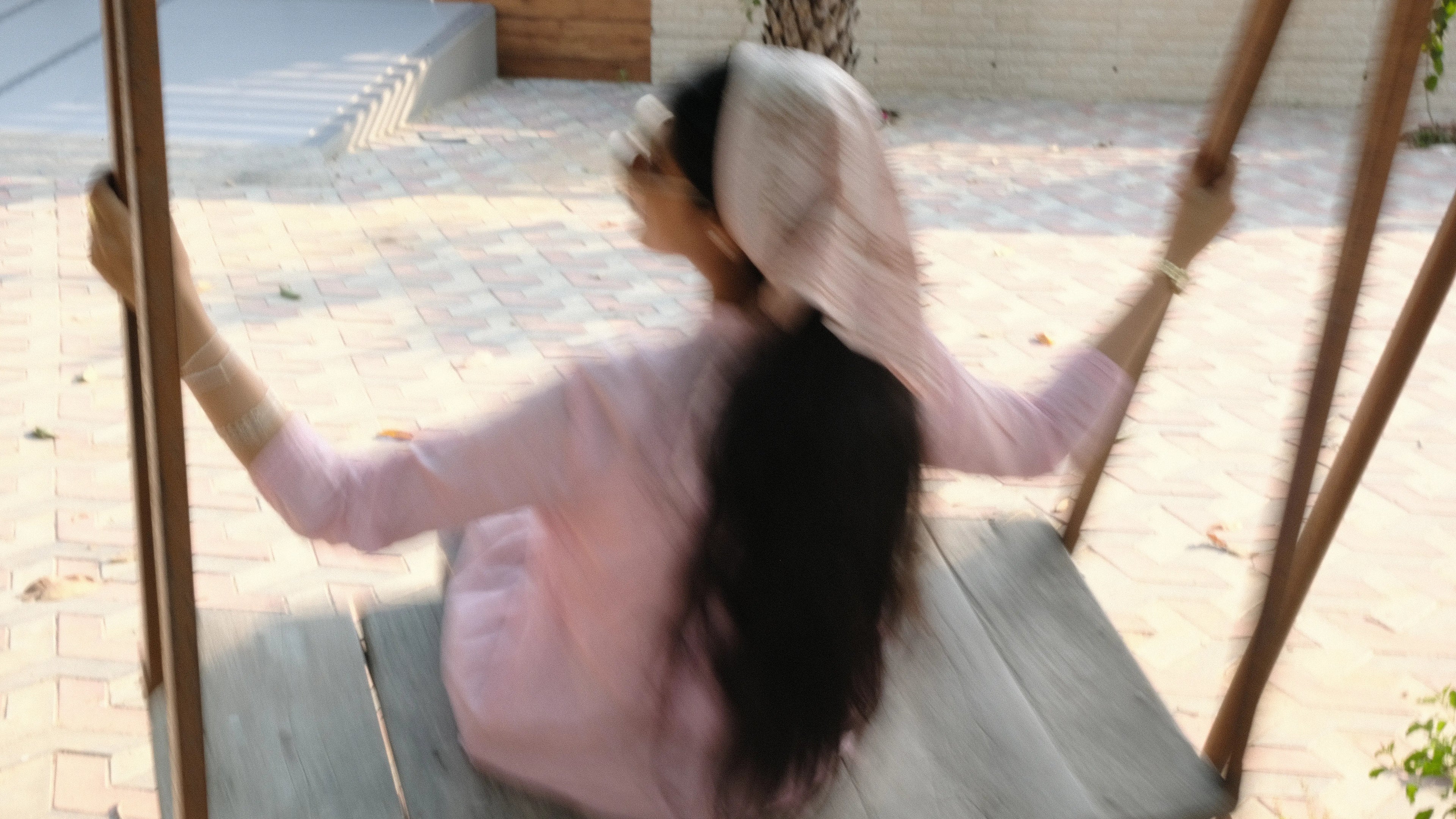 girl swinging outside wearing a headscarf
