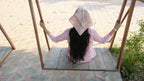 Person sitting on a swing with a scenic background