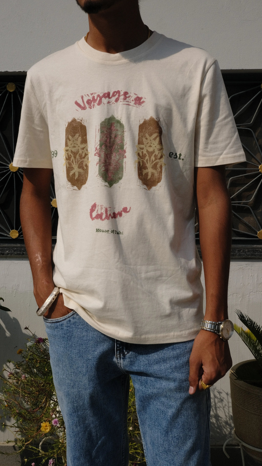 man wearing a hanprinted tshirt standing in a panjabi courtyard