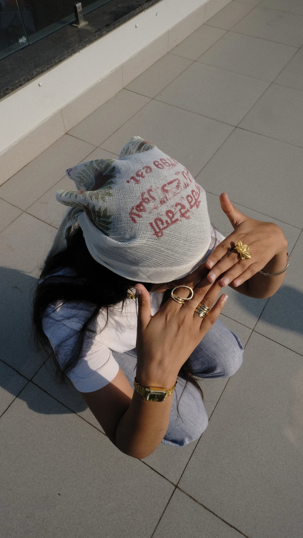 Girl hiding her face away from the sun using a scarf as protection